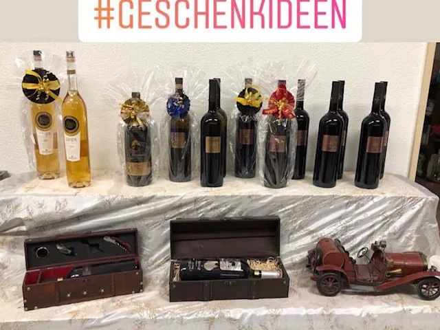 Geschenkflaschen mit Schleifen und Geschenkschachteln auf einem Tisch im Abholmarkt