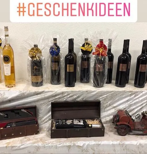 Geschenkflaschen mit Schleifen und Geschenkschachteln auf einem Tisch im Abholmarkt